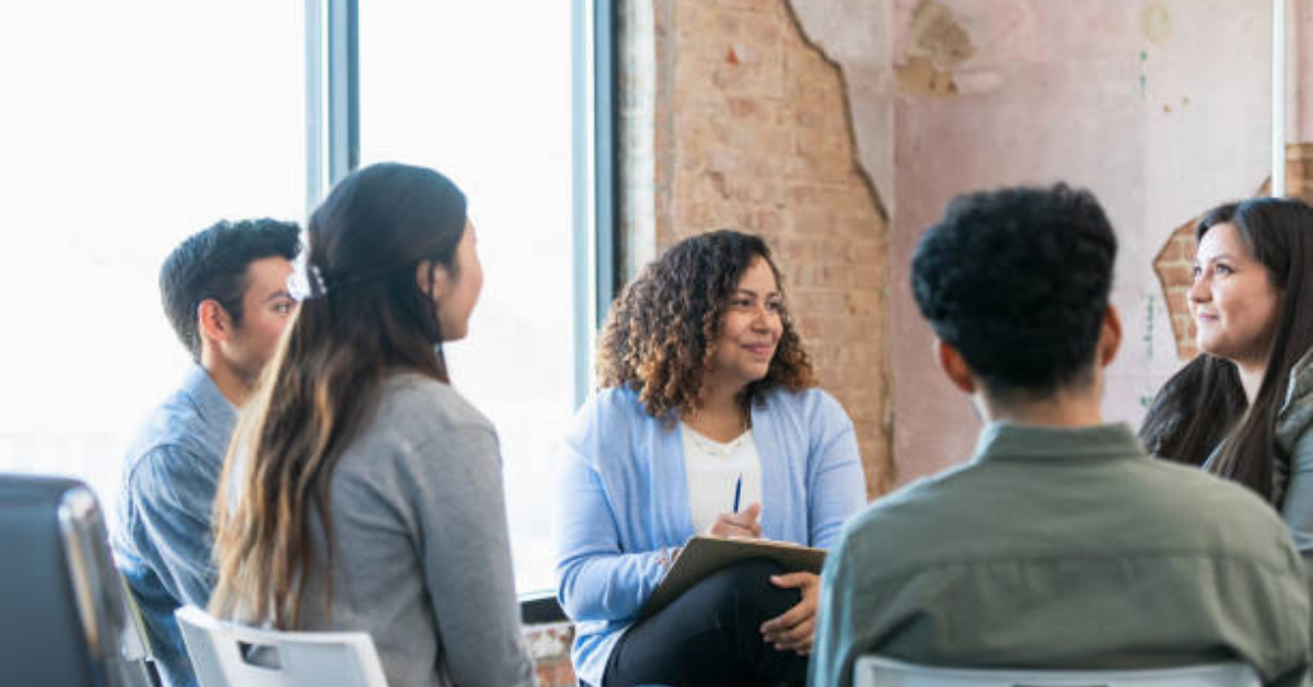 Participants in a group therapy session, sharing experiences and supporting each other in a safe, empowering environment